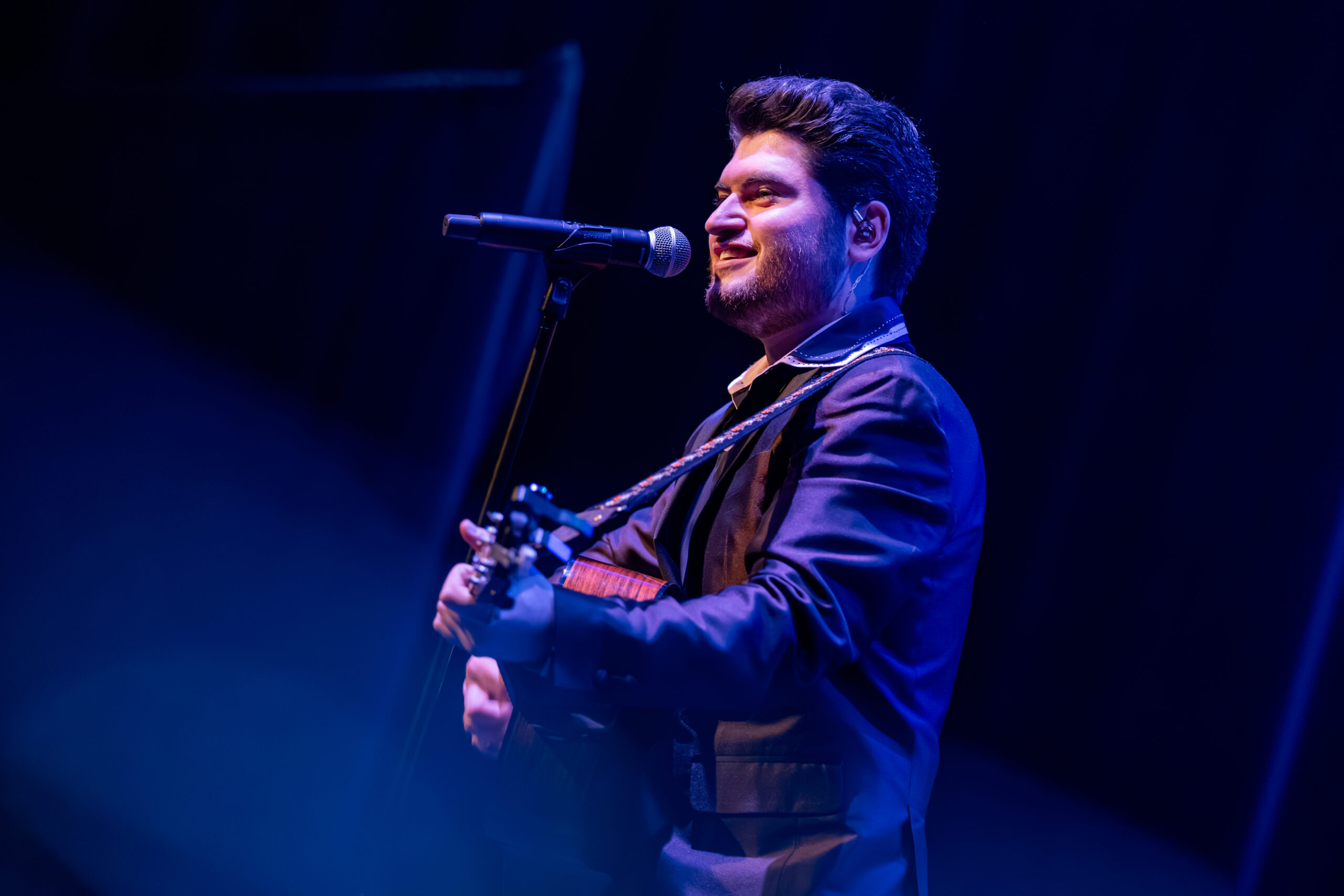 David Thibault souriant au micro, guitare à la main